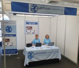 Two team members from the LATITUDES Network manning a conference stand.